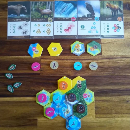 A solo game of Cascadia in progress, showing a number of tiles and animals placed, five score cards, selection tokens, and unselected tiles and animals.